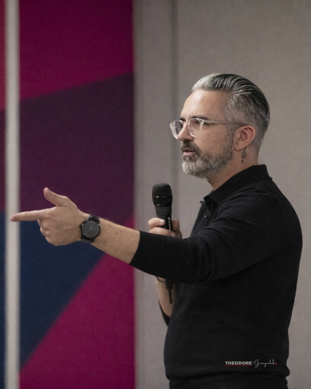 Theodore Georgedakis speaking, gesturing toward audience